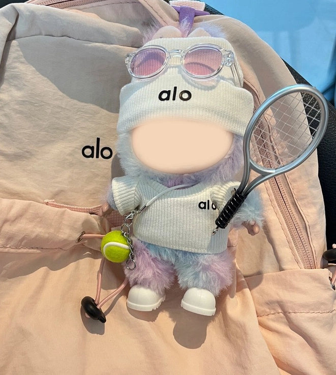 Labubu dressed in a pink tennis outfit holding miniature racket and ball.